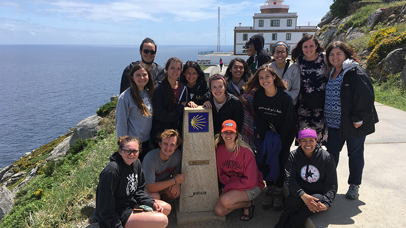 Students pause at an overlook next to the ocean.