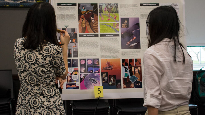 Female students in front of a research poster